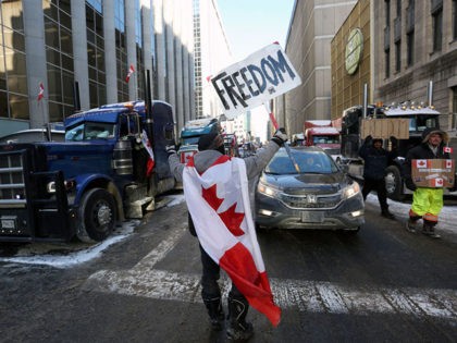 A person holds a sign reading "Freedom" as truckers and supporters continue to protest against mandates and restrictions related to Covid-19 vaccines in Ottawa, Ontario, Canada, on February 5, 2022. - Protesters again poured into Toronto and Ottawa early on February 5 to join a convoy of truckers whose occupation …