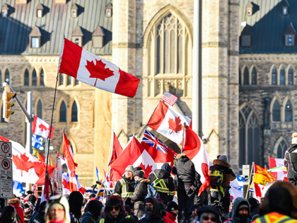 Supporters of the truckers against vaccine mandates implemented by Canadian Prime Minister Justin Trudeau, hold up Canadian flags as they gather near Parliament Hill on February 5, 2022 in Ottawa, Canada. Truckers continue their rally over the weekend near Parliament Hill in hopes of pressuring the government to roll back …