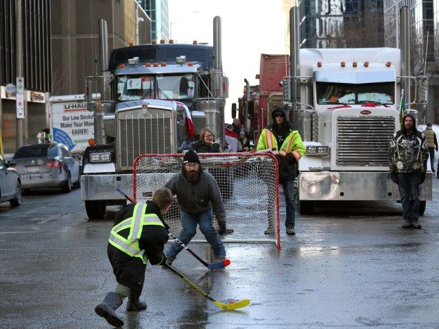 TOPSHOT - Protesters and supporters play street hockey as demonstrators continue to protest the vaccine mandates implemented by Prime Minister Justin Trudeau on February 7, 2022 in Ottawa, Canada. - Canadian authorities struggled Monday to tackle a truckers' protest against Covid restrictions which has paralyzed the national capital for days …