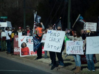 Protesters greet a motorcade with US President Joe Biden while it travels to Germanna Community College February 10, 2022, in Culpeper, Virginia. - Biden travels to Virginia to talk about lowering prescription drug costs. (Photo by Brendan Smialowski / AFP) (Photo by BRENDAN SMIALOWSKI/AFP via Getty Images)