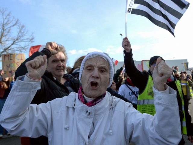 Protesters react as a so-called "Freedom Convoy" (Convoi de la Liberte) passes through Le Mans, western France, on February 11, 2022. - Thousands of protesters in convoys, inspired by Canadian truckers paralysing border traffic with the US, were heading to Paris from across France on February 11, with some hoping …