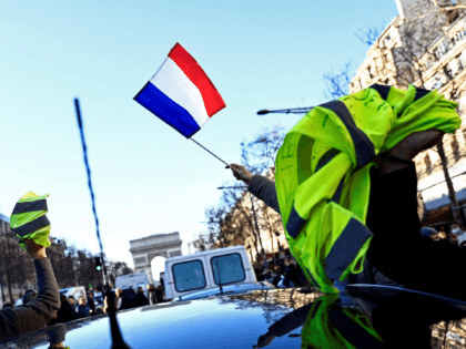 Demonstraters wave French flags and yellow vests on the Champs Elysees in Paris on February 12, 2022 as convoys of protesters so called "Convoi de la Liberte" arrived in the French capital. - Thousands of protesters in convoys, inspired by Canadian truckers paralysing border traffic with the US, were heading …