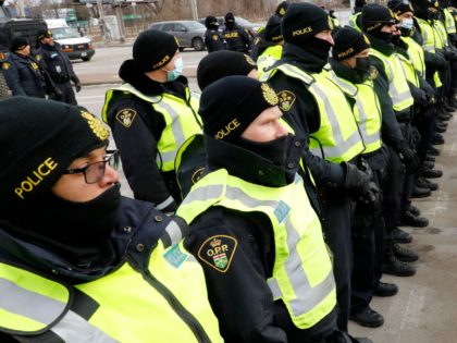 Protestors against Covid-19 vaccine mandates confront the Ontario Provincial Police as they try to clear the entrance to the Ambassador Bridge in Windsor, Ontario, Canada, on February 12, 2022. - Police in Canada were positioning Saturday to clear the bridge on the US border, snarled for days by truckers protesting …