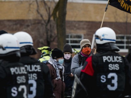 Counter-protesters are blocked off by anti-riot police as demonstrators march to support the Trucker Convoy protesting Covid-19 mandates, in Montreal on February 12, 2022. - Mandate protests and support for the truckers in Canada have spread from Ottawa. to Windsor, to Montreal, and Toronto. (Photo by Andrej Ivanov / AFP) …