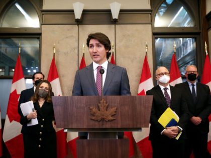 Canada's Prime Minister Justin Trudeau (C) comments on the on going truckers mandate protest during a news conference on Parliament Hill in Ottawa, Canada on February 14, 2022. - Canadian Prime Minister Justin Trudeau on February 14, 2022 invoked rarely-used emergency powers to bring an end to trucker-led protests against …