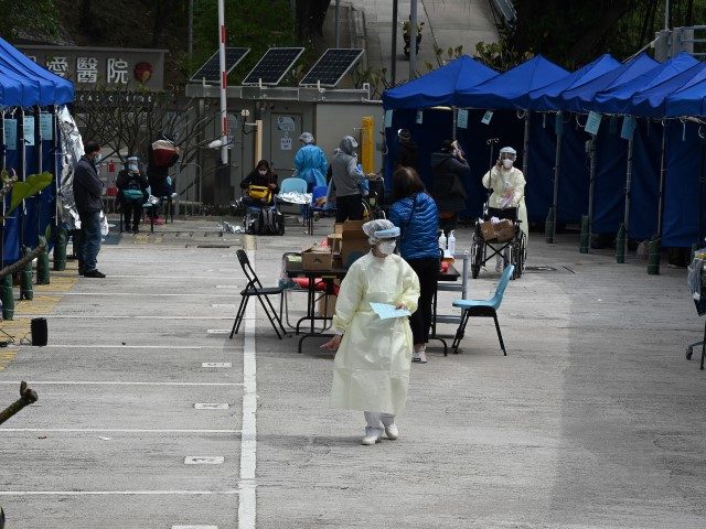 A nurse (C) walks through a temporary centre for patients set up outside the Caritas Medical Centre in Hong Kong on February 16, 2022, as the city faces its worst Covid-19 coronavirus wave to date.