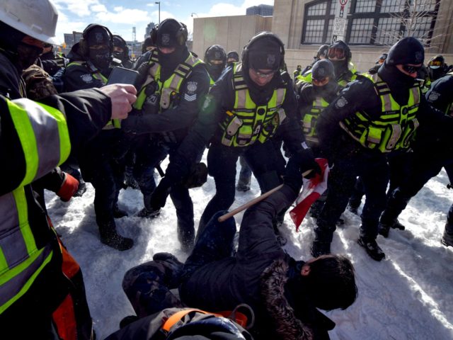 TOPSHOT - Police clash with demonstrators against Covid-19 mandates in Ottawa on February 18, 2022. - Canadian police on Thursday began a massive operation to clear the trucker-led protests against Covid health rules clogging the capital for three weeks, with several arrests made. (Photo by Ed JONES / AFP) (Photo …