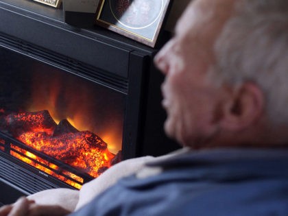 BRISTOL, ENGLAND - OCTOBER 06: In this photo illustration, an elderly man warms himself in front of a fire on October 6, 2011 in Bristol, England. Energy price rises and an increase in the cost of living has resulted in more people, including the elderly, with energy debts with a …