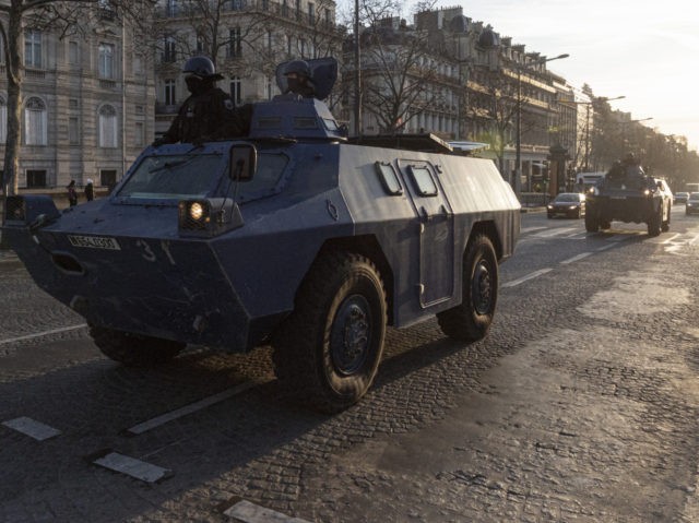 PARIS, FRANCE - FEBRUARY 12: Armoured police vehicles drive along the Champs Elysees as th