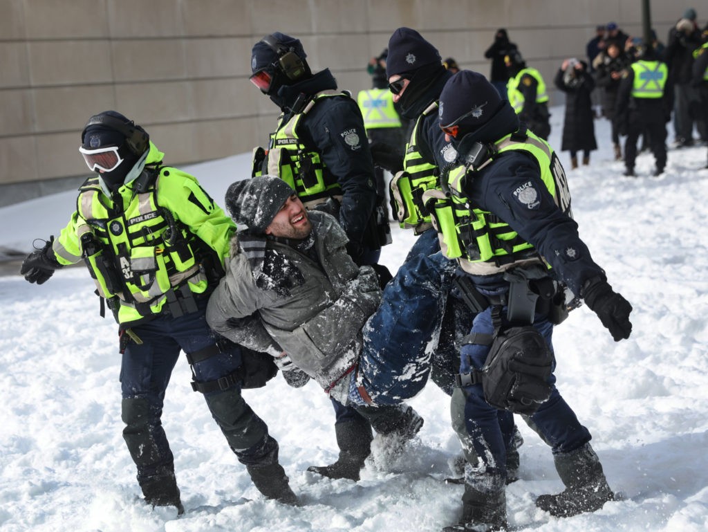 OTTAWA, ONTARIO - FEBRUARY 18: A demonstrator is taken into custody as the police begin to break up a protest organized by truck drivers opposing vaccine mandates on February 18, 2022 in Ottawa, Ontario, Canada The drivers have used vehicles to form a blockade that has blocked several streets near Parliament Hill. Prime Minister Justin Trudeau has invoked the Emergencies Act in an attempt to try to put an end to the demonstration that has nearly paralyzed a portion of downtown Ottawa for 22 days. (Photo by Scott Olson/Getty Images)