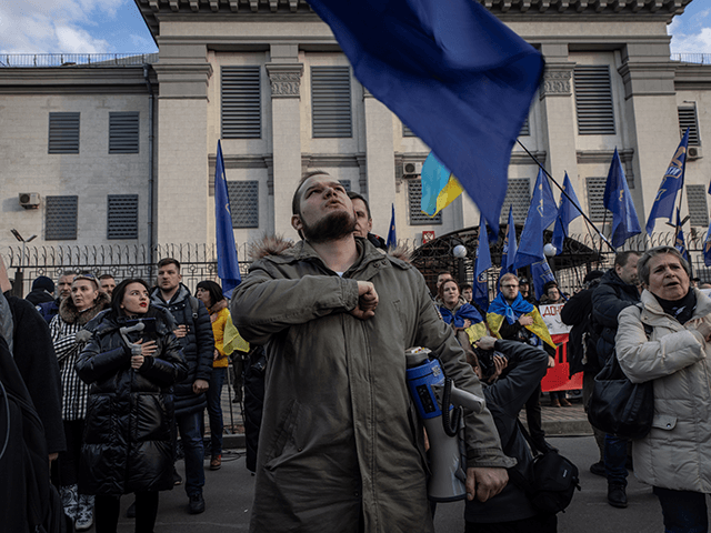 People sing the Ukrainian national anthem during a protest outside the Russian Embassy on February 22, 2022 in Kyiv, Ukraine. After Russian forces concluded large-scale military exercises in Belarus amid a tense diplomatic standoff between Russia and Ukraine's Western allies, Russian President Vladimir Putin in a nation wide televised statement, recognized the independence of two breakaway regions in Eastern Ukraine and has since sent Russian "peacekeepers" to the area raising fears of a full-scale invasion. (Photo by Chris McGrath/Getty Images)