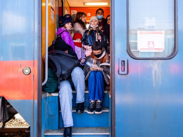 ZAHONY, HUNGARY - FEBRUARY 28: People fleeing the Ukraine board trains after crossing the