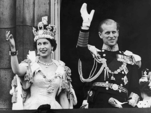 Queen Elizabeth II and the Duke of Edinburgh wave at the crowds from the balcony at Buckingham Palace after Elizabeth's coronation, 2nd June 1953. (Photo by Keystone/Hulton Archive/Getty Images)