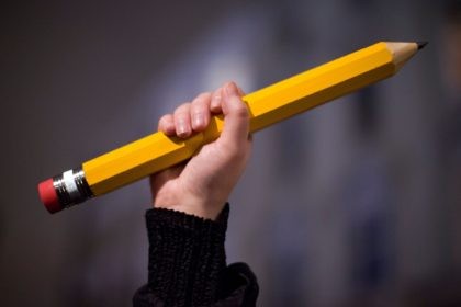 A giant pencil is held up at a vigil outside The French Institute in London on January 9,