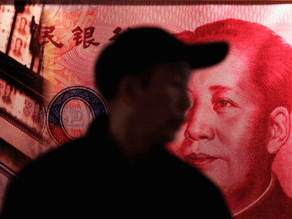 BEIJING - DECEMBER 09: A man walks past a billboard featuring the late chaiman Mao Zedong on a Chinese banknote at a finance exhibition held by the People's Bank of China on December 9, 2005 in Beijing, China. China's banking regulatory body says the full opening up of its banking …