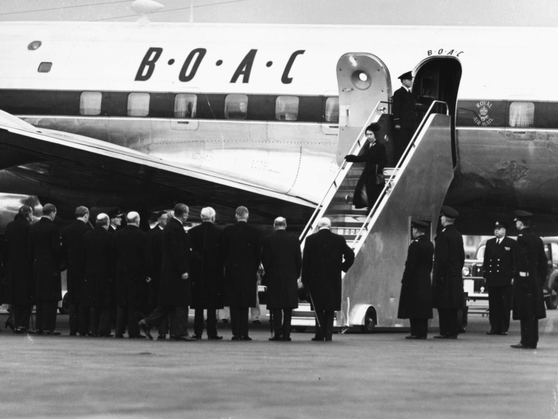 Queen Elizabeth II and Prince Philip, the Duke of Edinburgh, leaving their BOAC airliner as they return from Kenya following the death of King George VI and Elizabeth's accession to the throne, London, February 7th 1952. (Photo by Keystone/Hulton Archive/Getty Images)