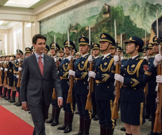 Canada's Prime Minister Justin Trudeau and China's Premier Li Keqiang (2nd L) walk pasy Chinese paramilitary guards during a welcome ceremony at the Great Hall of the People in Beijing on December 4, 2017. / AFP PHOTO / Fred DUFOUR (Photo credit should read FRED DUFOUR/AFP via Getty Images)