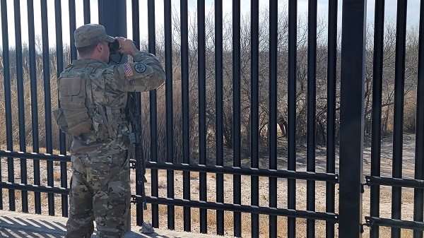 A Texas National Guard soldier observes a Rio Grande border crossing area in Del Rio, Texas, under Operation Lone Star. (Bob Price/Breitbart Texas)