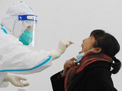 A resident undergoes a nucleic acid test for the Covid-19 coronavirus in Hangzhou in China's eastern Zhejiang province on January 28, 2022.