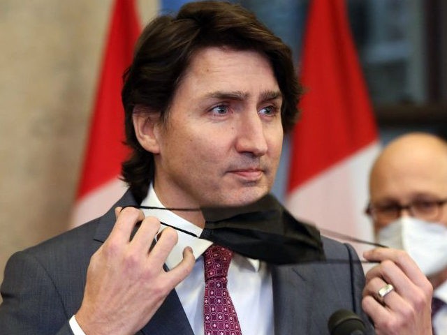 Canada's Prime Minister Justin Trudeau removes his mask during a news conference on Parlia