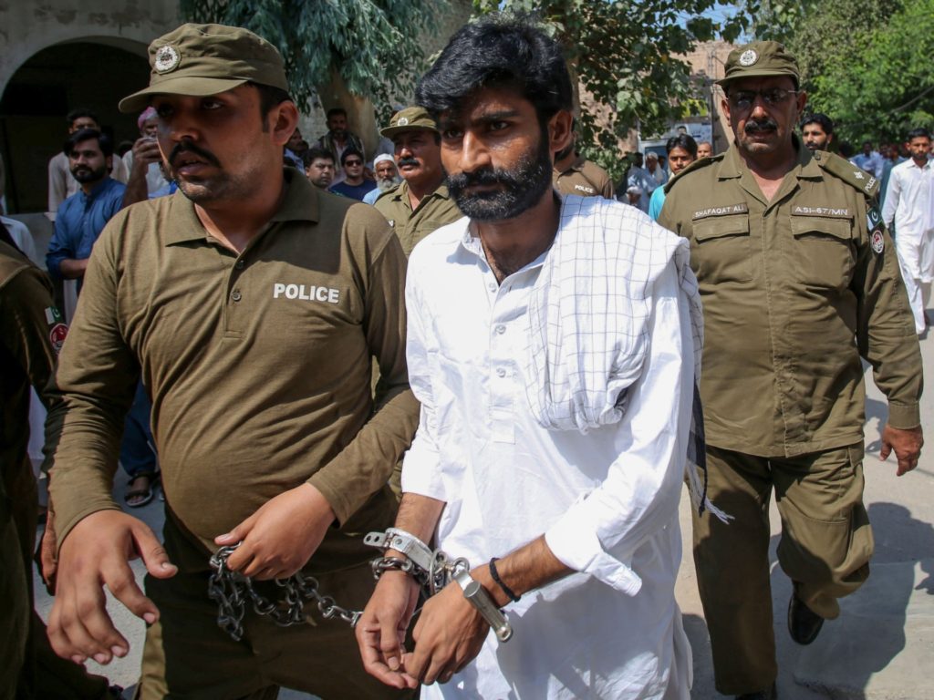 Policemen escort hand-cuffed Muhammad Waseem (C), the brother of slain social media celebrity Qandeel Baloch, as he leaves the court after the verdict in Multan on September 27, 2019. - The brother of Pakistani social media star Qandeel Baloch was on September 27 sentenced to life in prison for her murder -- the patriarchal country's highest-profile "honour killing". (Photo by SS MIRZA / AFP) (Photo credit should read SS MIRZA/AFP/Getty Images)