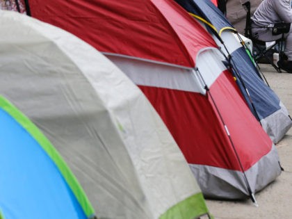 People hoping to become carpenters apprentices use tents while waiting in line in New York, Sunday, April 8, 2018. The line was formed two nights ago for a chance to apply for an apprenticeship with the New York City carpenters' union. (AP Photo/Seth Wenig)