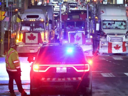 A police vehicle blocks a downtown street to prevent trucks from joining a blockade of tru