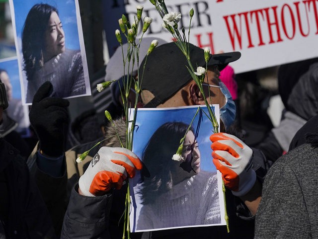 People hold signs and pictures of Christina Yuna Lee during a rally in the Chinatown secti