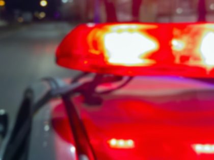 Police car red lights in night time, crime scene, night patrolling the city. Abstract blurry image. - stock photo