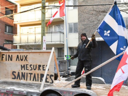 Protesters on a flat bed truck hold up Canadian and Quebec flags on February 5, 2022 in Ottawa, Canada.(Photo by Minas Panagiotakis/Getty Images)