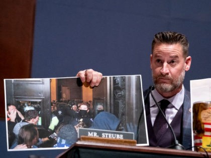 Rep. Greg Steube (R-FL) holds a photo from the January 6 attack on the Capitol (L) and a r