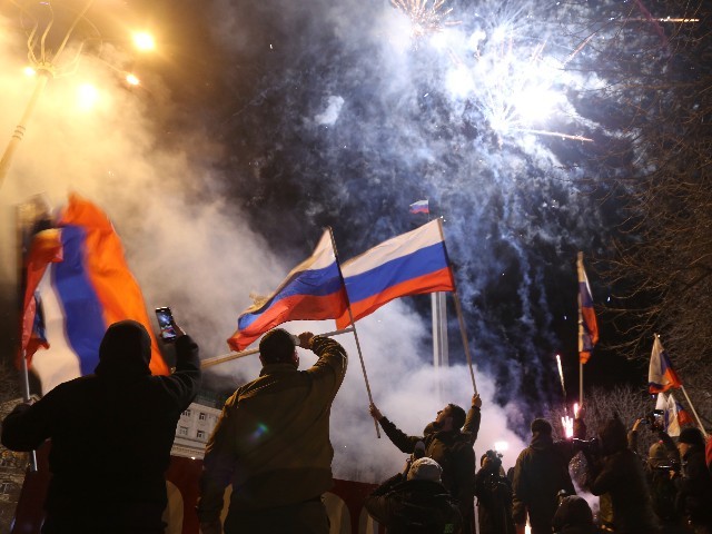 People celebrate the recognizing the independence waving Russian national flag in the center of Donetsk, the territory controlled by pro-Russian militants, eastern Ukraine, late Monday, Feb. 21, 2022. In a fast-moving political theater, Russian President Vladimir Putin has moved quickly to recognize the independence of separatist regions in eastern Ukraine in a show of defiance against the West amid fears of Russian invasion in Ukraine. (AP Photo/Alexei Alexandrov)