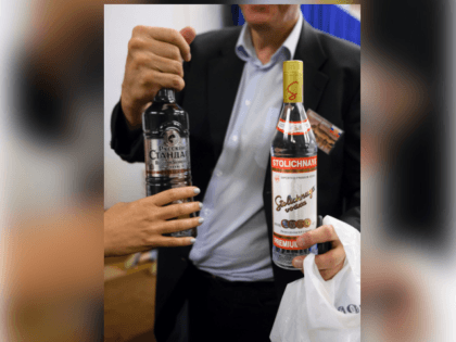 A journalist holds two bottles of vodka that Russian Foreign Minister Sergei Lavrov delive