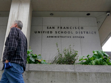 A pedestrian walks past a San Francisco Unified School District office building in San Francisco, Thursday, Feb. 3, 2022. A seemingly endless amount of drama, name-calling, lawsuits _ and outrage from parents and city officials _ made the saga of San Francisco's school board a riveting pandemic sideshow that is …