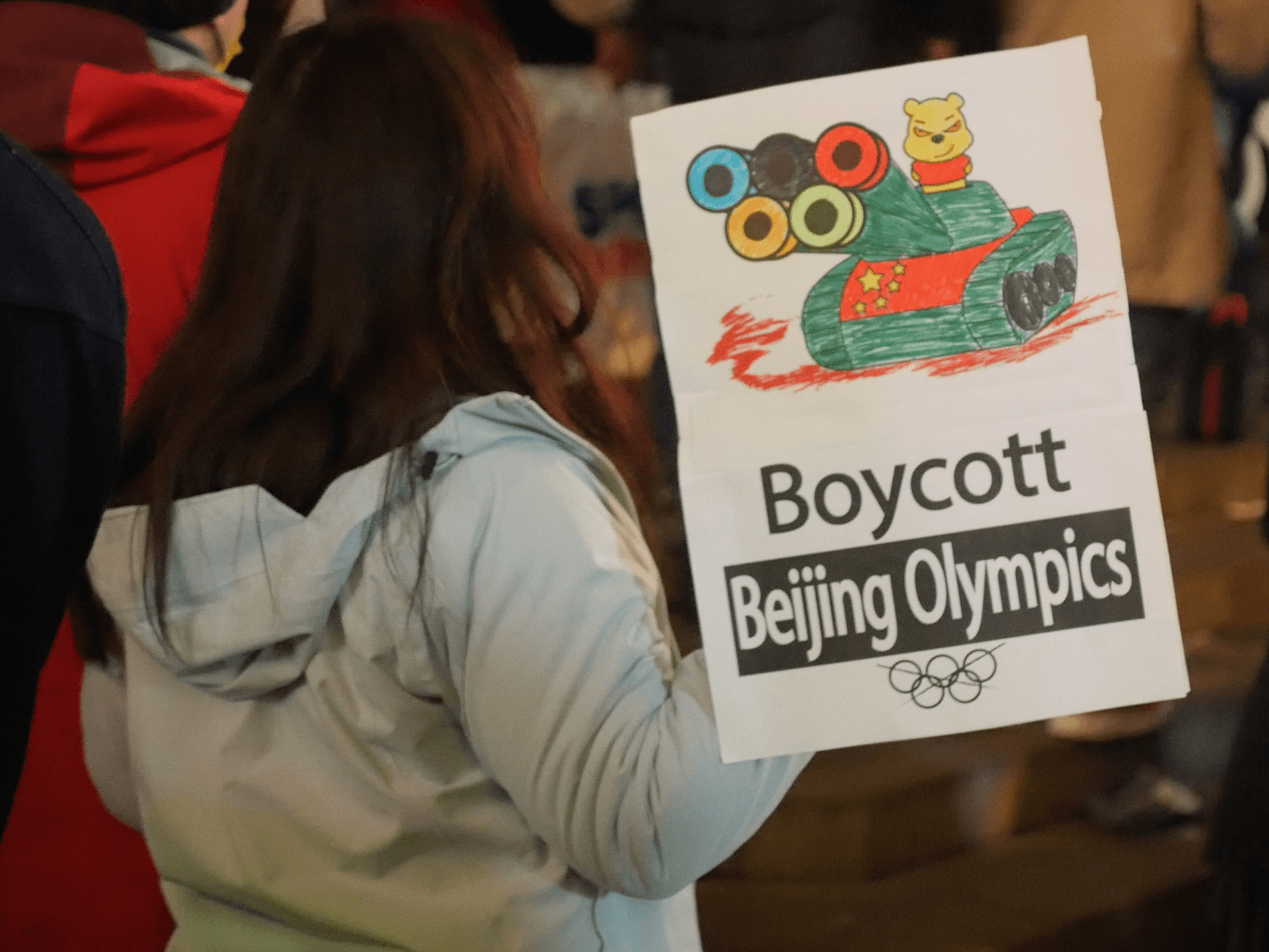 An activist holds a placard mocking Xi Jinping as Winnie the Pooh at a protest in London against the Beijing Olympics, February 3rd, 2022. Kurt Zindulka, Breitbart News