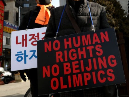 Protesters hold placards reading, "No Human Rights, No Beijing Olympics," during