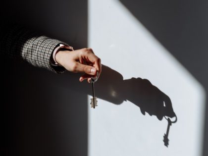 Shadow on a Wall of a Hand Holding a Key