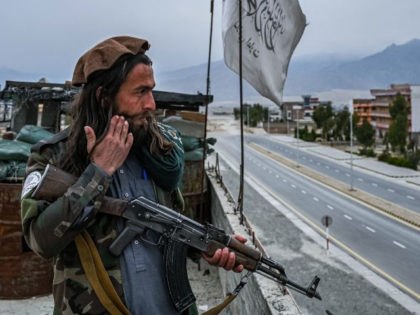 A Taliban fighter mans a post on the roof top of the main gate of Laghman University in Mihtarlam, Laghman province on February 2, 2022. (Photo by Mohd Rasfan/AFP via Getty Images)