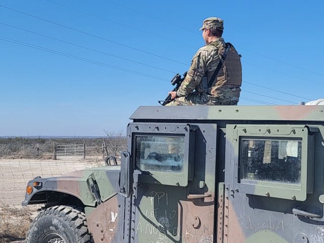 A Texas National Guardsman patrols the state's border with Mexico under Governor Greg Abbo