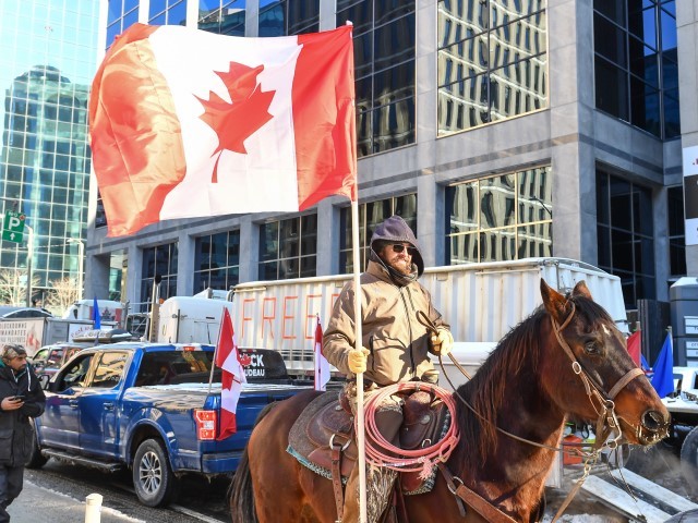 OTTAWA, ON - FEBRUARY 05: A supporter of the Freedom Convoy rides on horseback down Metcalfe Street on February 5, 2022 in Ottawa, Canada. Truckers continue their rally over the weekend near Parliament Hill in hopes of pressuring the government to roll back COVID-19 public health regulations and mandates.