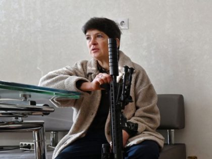 Mariana Jaglo, mother of three, talks on the phone as she holds her Ukrainian Z-15 - Zbroyar long rifle during an interview in the kitchen of her flat in Kiev on January 28, 2022. - As fears grow of a potential invasion by Russian troops massed on Ukraine's border, this …