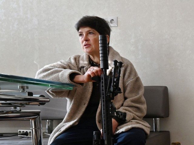 Mariana Jaglo, mother of three, talks on the phone as she holds her Ukrainian Z-15 - Zbroy