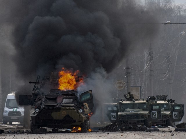 An armored personnel carrier burns and damaged light utility vehicles stand abandoned after fighting in Kharkiv, Ukraine, Sunday, Feb. 27, 2022. The city authorities said that Ukrainian forces engaged in fighting with Russian troops that entered the country's second-largest city on Sunday.