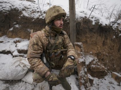 An Ukrainian serviceman sits at his position in a trench on the front line in the Luhansk region, eastern Ukraine, Friday, Jan. 28, 2022. High-stakes diplomacy continued on Friday in a bid to avert a war in Eastern Europe. The urgent efforts come as 100,000 Russian troops are massed near …