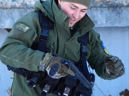 Member of Georgian Legion Justin Dee, 24, from New York, holds a gun as he trains civilians to adapt them with the self-defense capabilities in case of Russian invasion in Kyiv, Ukraine, Friday, Feb. 4, 2022. (AP Photo/Efrem Lukatsky)