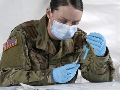 FILE - U.S. Army medic Kristen Rogers of Waxhaw, N.C. fills syringes with the Johnson & Johnson COVID-19 vaccine, Wednesday, March 3, 2021, in North Miami, Fla. Critics in Florida say a doctor’s signature required for some people to get vaccinated is adding onerous barriers for some eligible residents, especially …