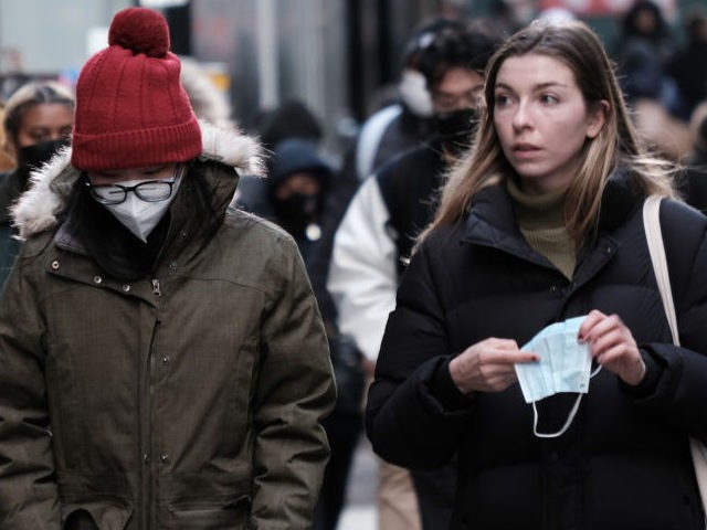People wear face masks in Manhattan on November 29, 2021 in New York City. Across New York