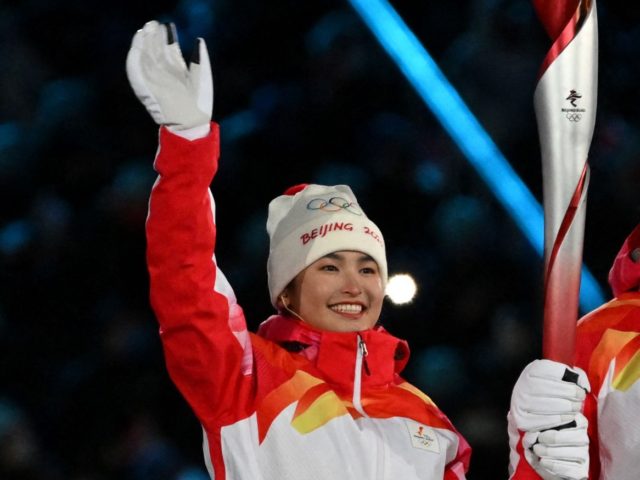 Chinese torchbearer athletes Dinigeer Yilamujian (L) and Zhao Jiawen hold the Olympic flame during the opening ceremony of the Beijing 2022 Winter Olympic Games, at the National Stadium, known as the Bird's Nest, in Beijing, on February 4, 2022. - Dinigeer Yilamujiang is a cross-country skier and Zhao Jiawen a …