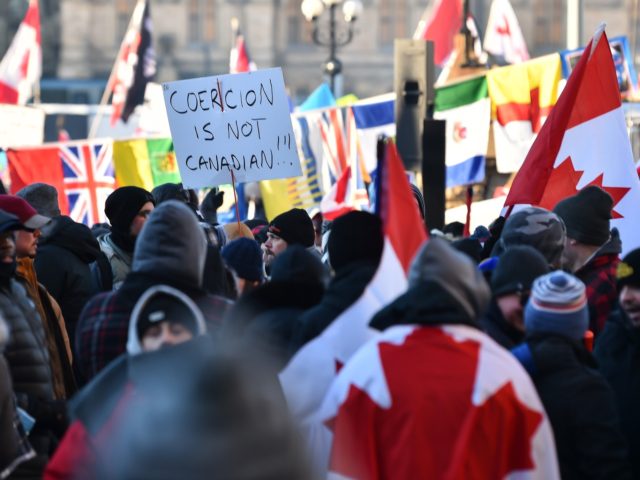 OTTAWA, ON - FEBRUARY 05: Protesters near Parliament Hill hold signs condemning the vaccine mandates imposed by Canadian Prime Minister Justin Trudeau on February 5, 2022 in Ottawa, Canada. Truckers continue their rally over the weekend near Parliament Hill in hopes of pressuring the government to roll back COVID-19 public …