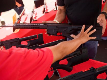 clerk shows a customer a TPM Arms LLC California-legal featureless AR-10 style .308 rifle displayed for sale at the company's booth at the Crossroads of the West Gun Show at the Orange County Fairgrounds on June 5, 2021 in Costa Mesa, California. - Gun sales increased in the US following …